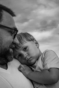 Kind kuschelt mit Papa Familienfotos