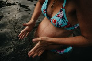 Babybauch Fotoshooting nackter Bauch im Wasser